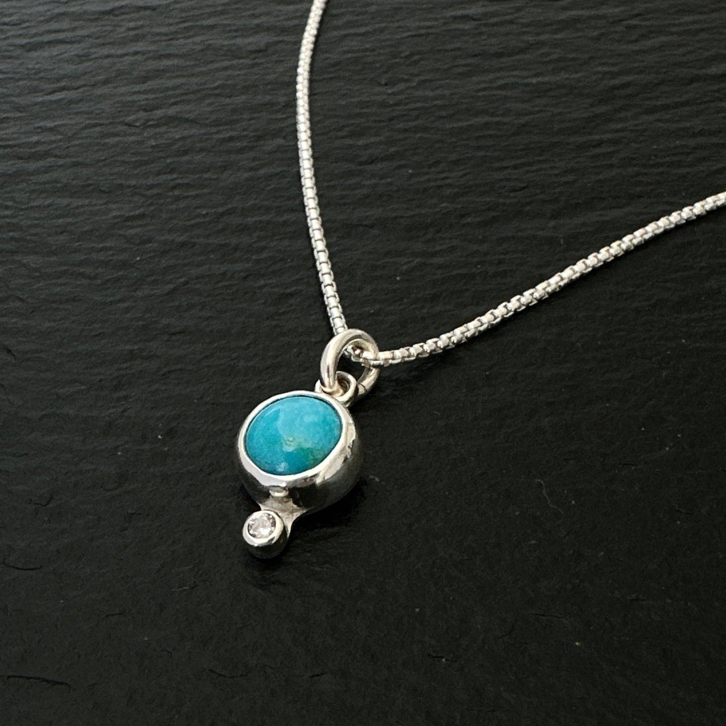 Necklace with a turquoise pendant on a black background