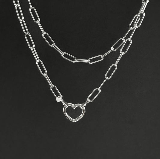 Silver chain necklace with a heart pendant on a black background