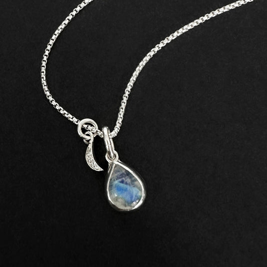 Silver necklace with a teardrop-shaped moonstone pendant on a black background