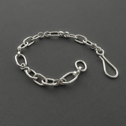 Silver chain bracelet on a dark gray background