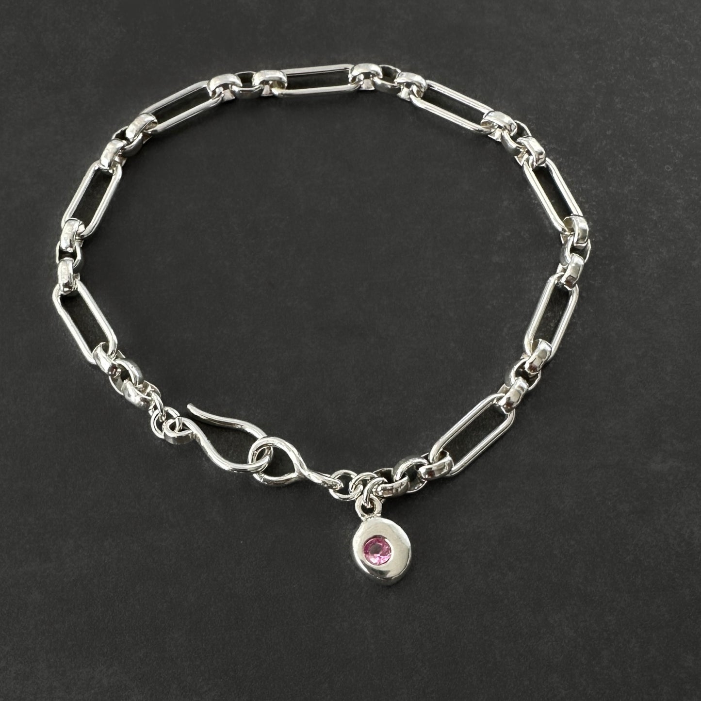 sterling silver bracelet with a pink gemstone charm 
