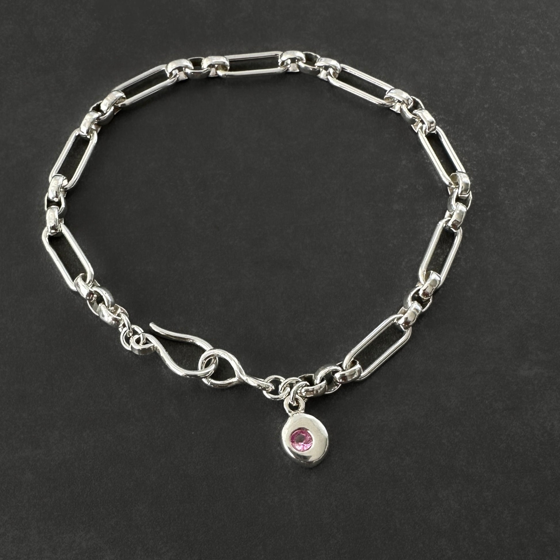 sterling silver bracelet with a pink gemstone charm 