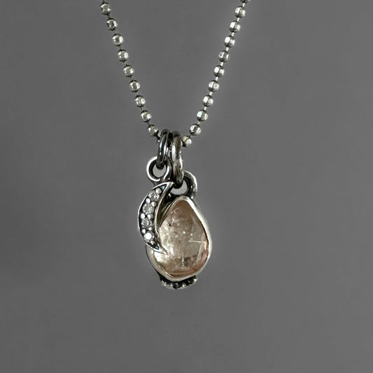 Necklace with a pendant featuring a teardrop-shaped tourmaline gemstone  and pave crescent moon charm 