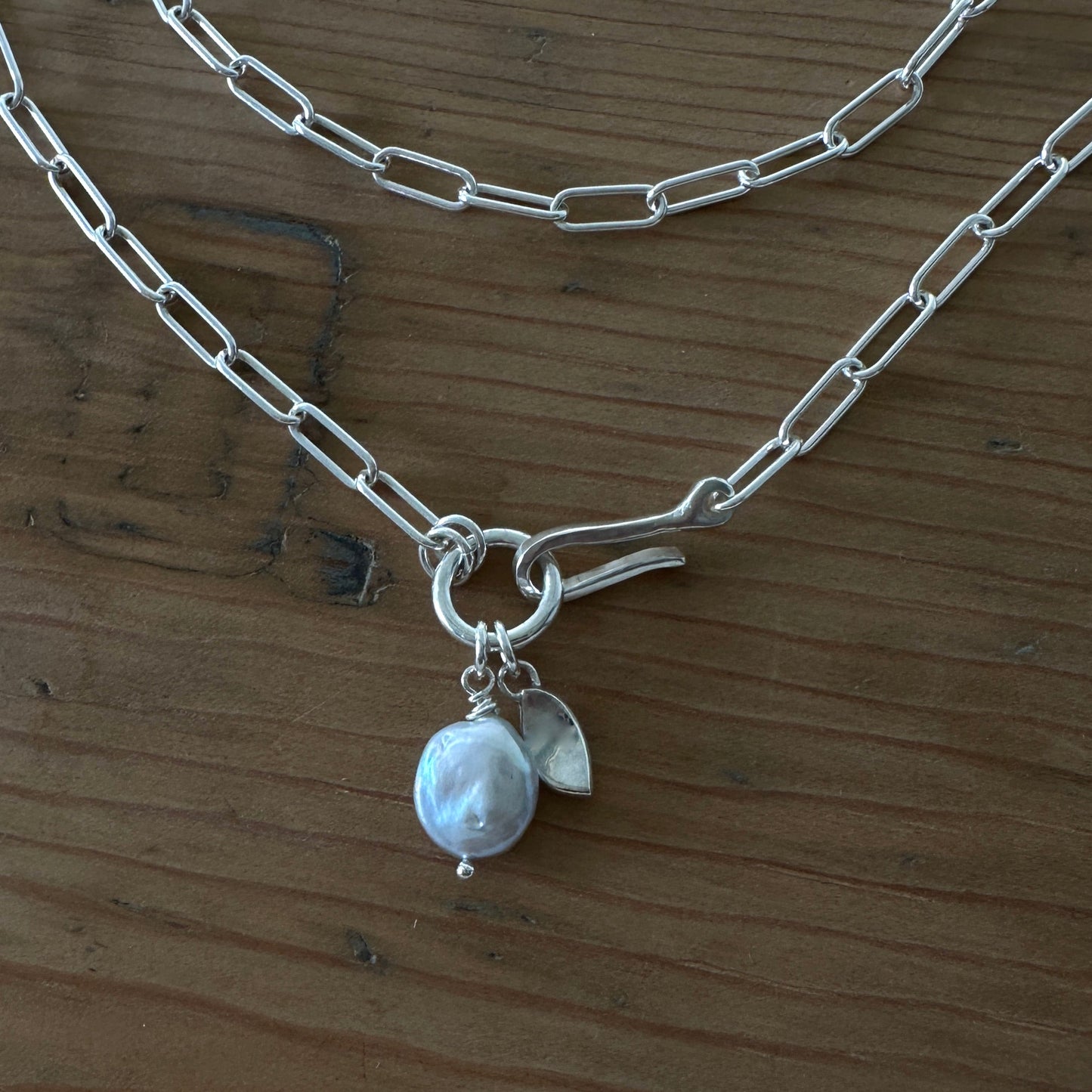 Silver chain necklace with a gray pearl and leaf charm 