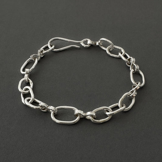 Silver chain bracelet on a dark gray background